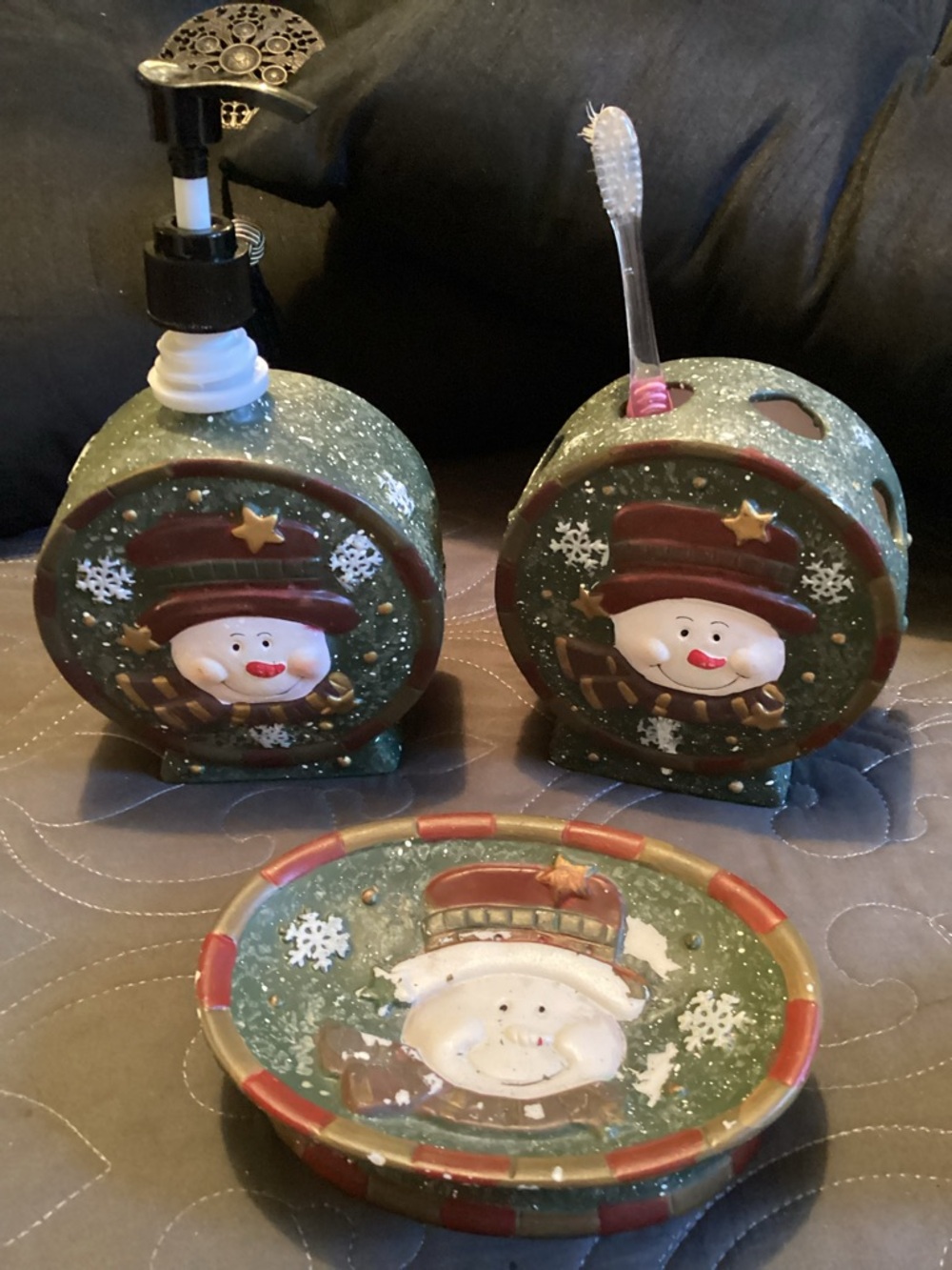 Festive bathroom set featuring a lotion dispenser, toothbrush holder